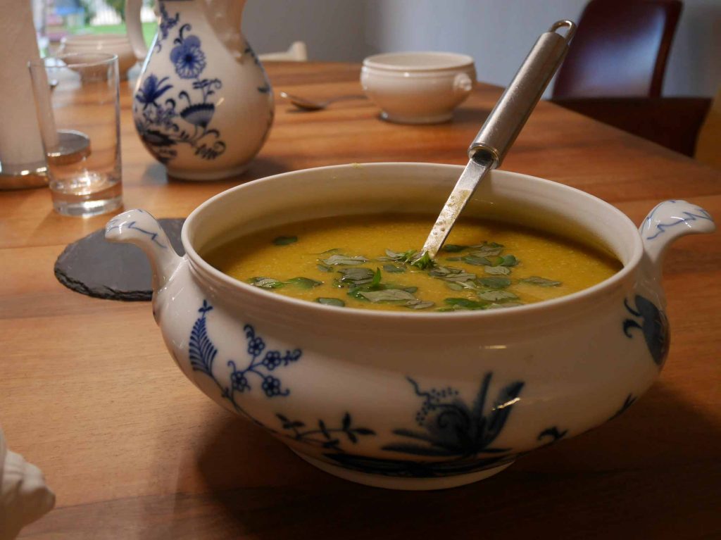 Eine Suppenschüssel mit Zwiebelmuster, voll mit Kartoffelsuppe