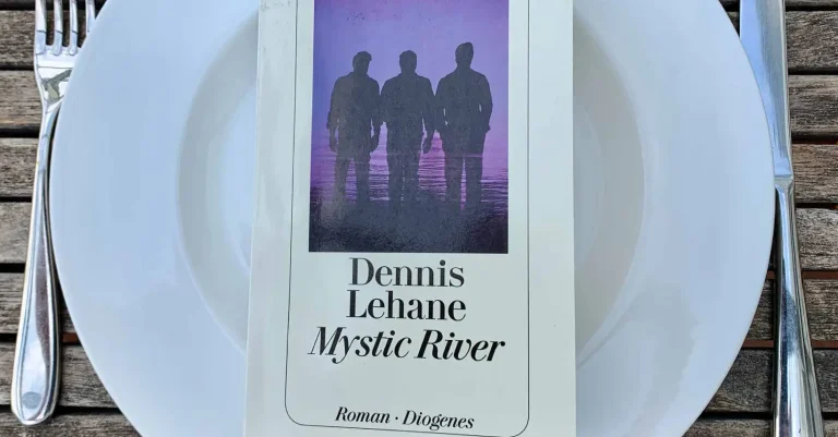 Der Roman „Mystic River“ von Dennis Lehane liegt auf einem Teller, daneben das Messer und Gabel. Bereit zur Buchbesprechung?