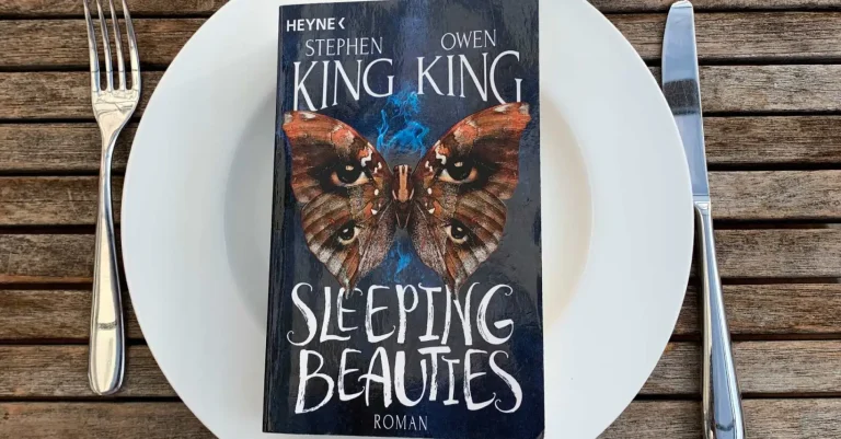 Der Roman „Sleeping Beauties“ von Stephen und Owen Kind liegt auf einem Teller, daneben das Messer und Gabel. Bereit zur Buchbesprechung?